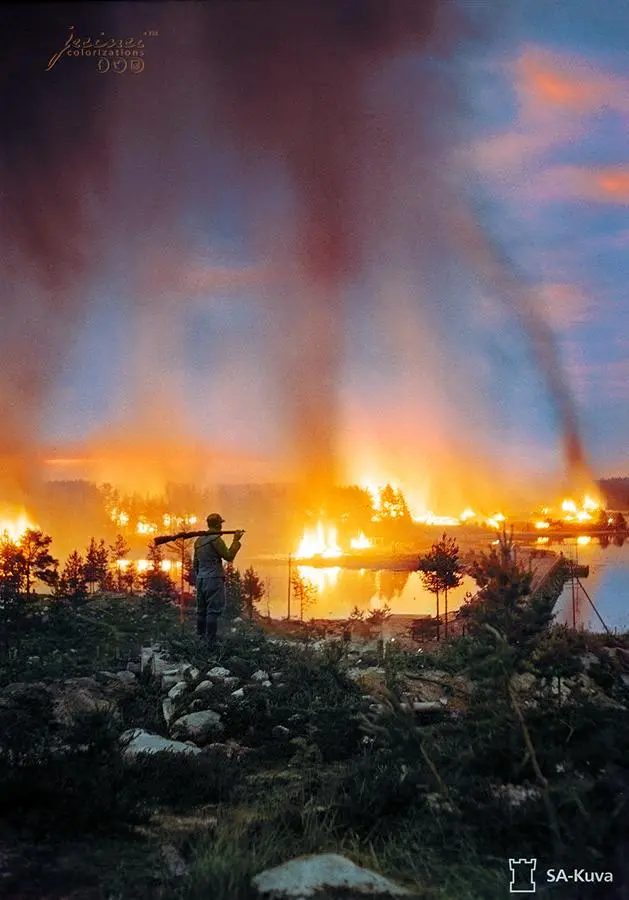 Finnish soldier, looking at a burning town in Karelia in 1944