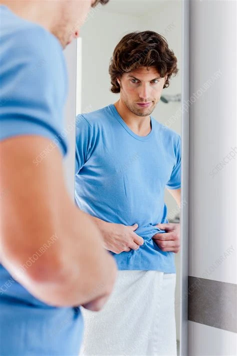 Stock photo of a white man looking at himself in a mirror