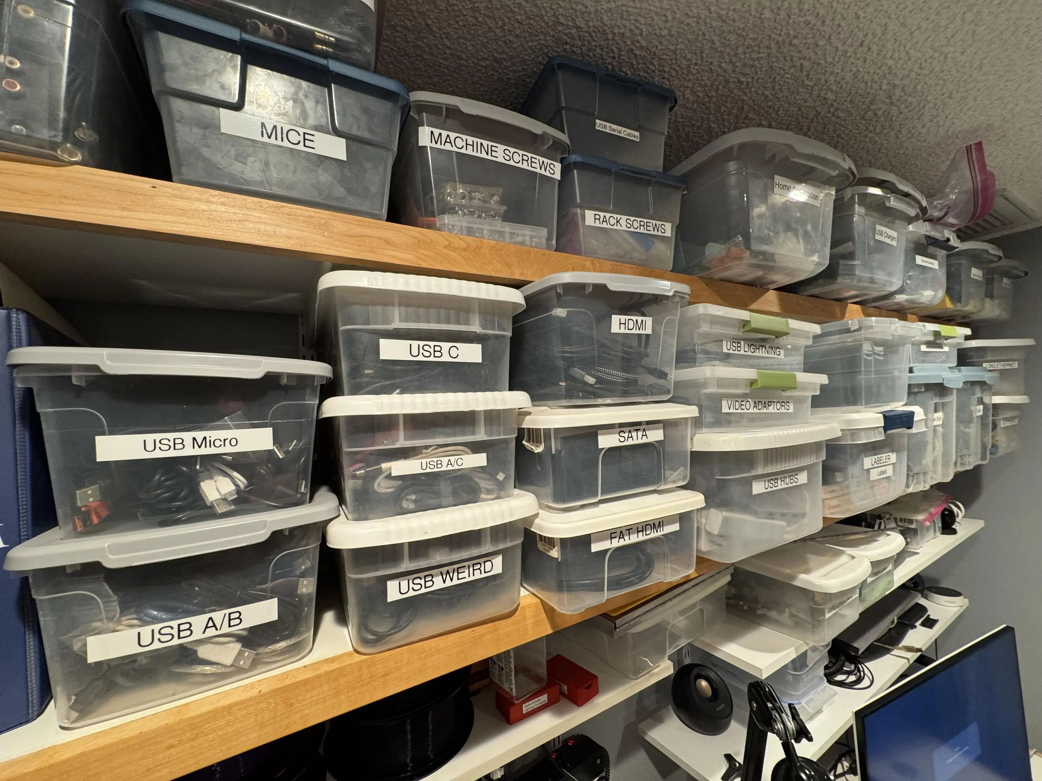 Photo of just some of the shelves with labeled bins containing weird cables. 