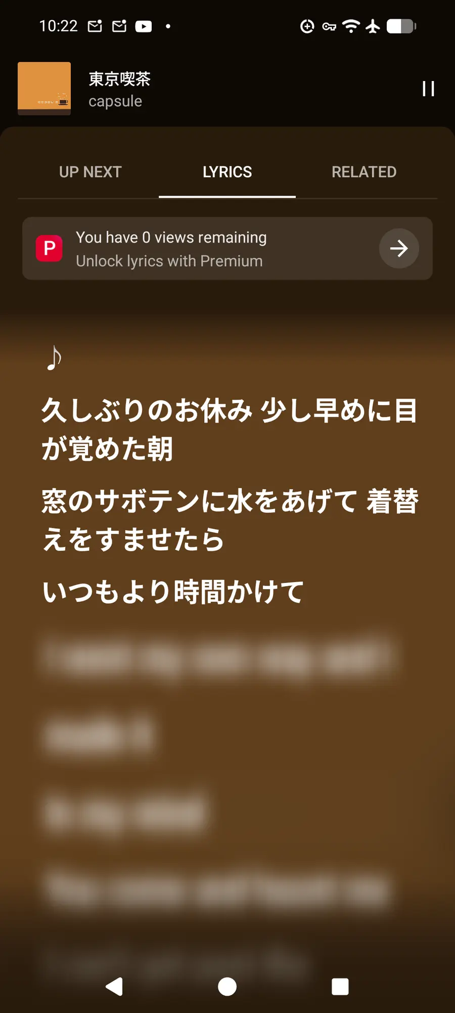 A screenshot of YouTube Music's Lyrics tab. The first three lines of the song are shown, the rest is blurred out. There's a button that says You habe 0 views remaining. Unlock lyrics with premium